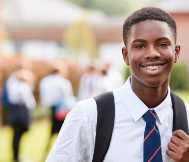 A school boy in uniform wearing a tie outside