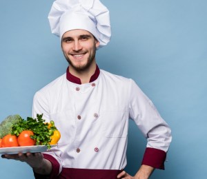 chef holds a plate of fresh vegetables