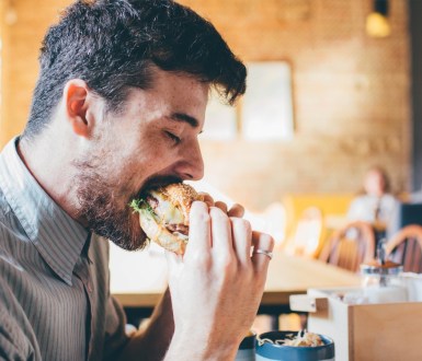 Man eating meat burger