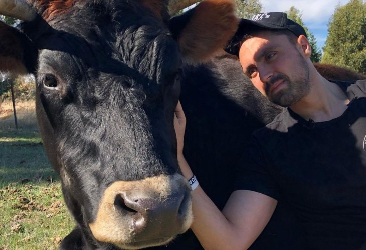 Vegan activist Joey Carbstrong with a cow