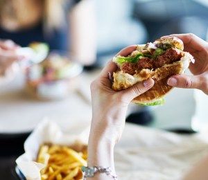 A person holding up a half eaten burger