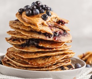 a stack vegan blueberry pancakes with peanut butter and syrup